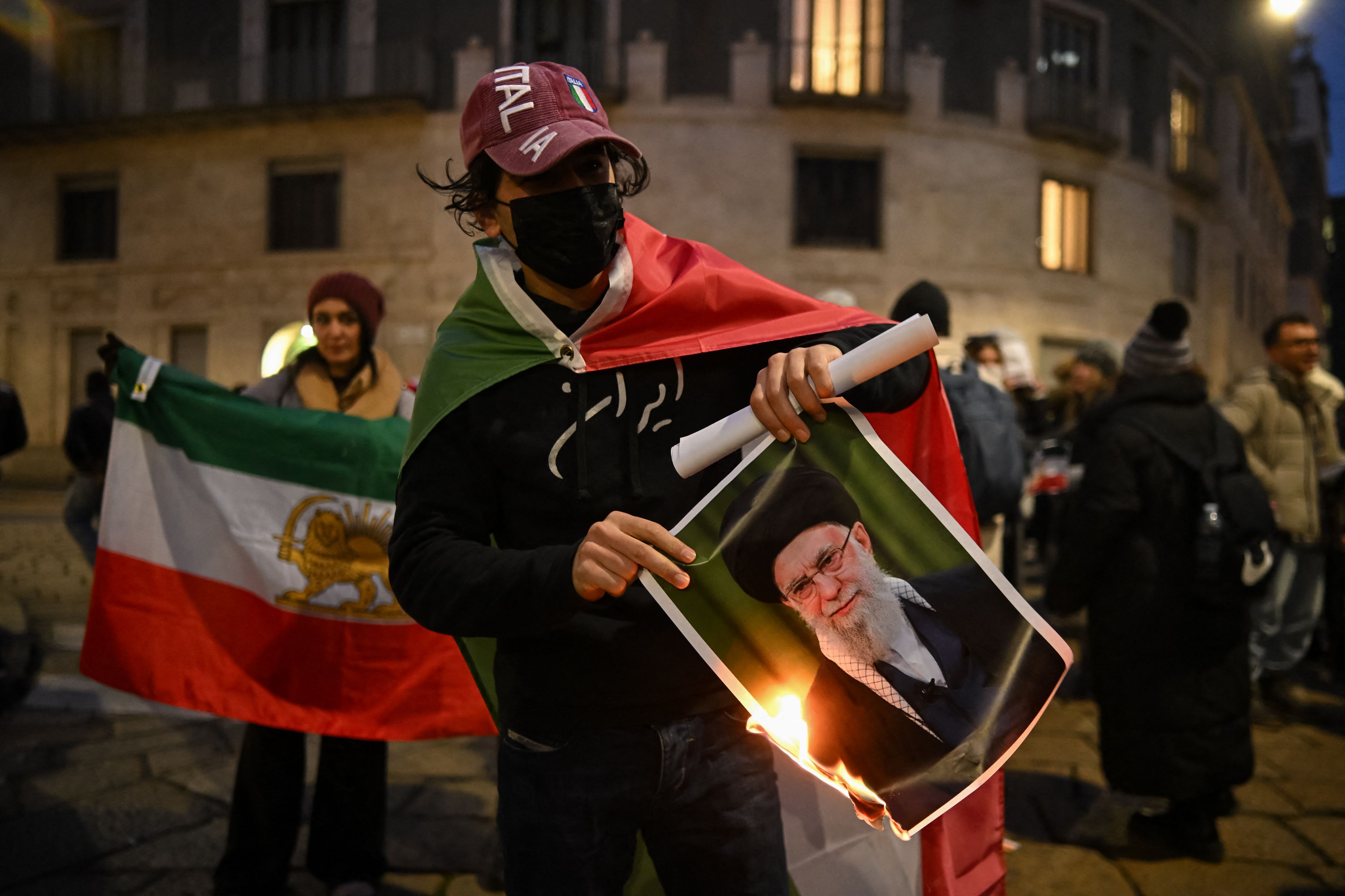 Un manifestant anti-régime iranien brûle une photo de Ali Khamenei, lors d'un rassemblement devant le consulat américain à Milan, le 13 janvier 2026